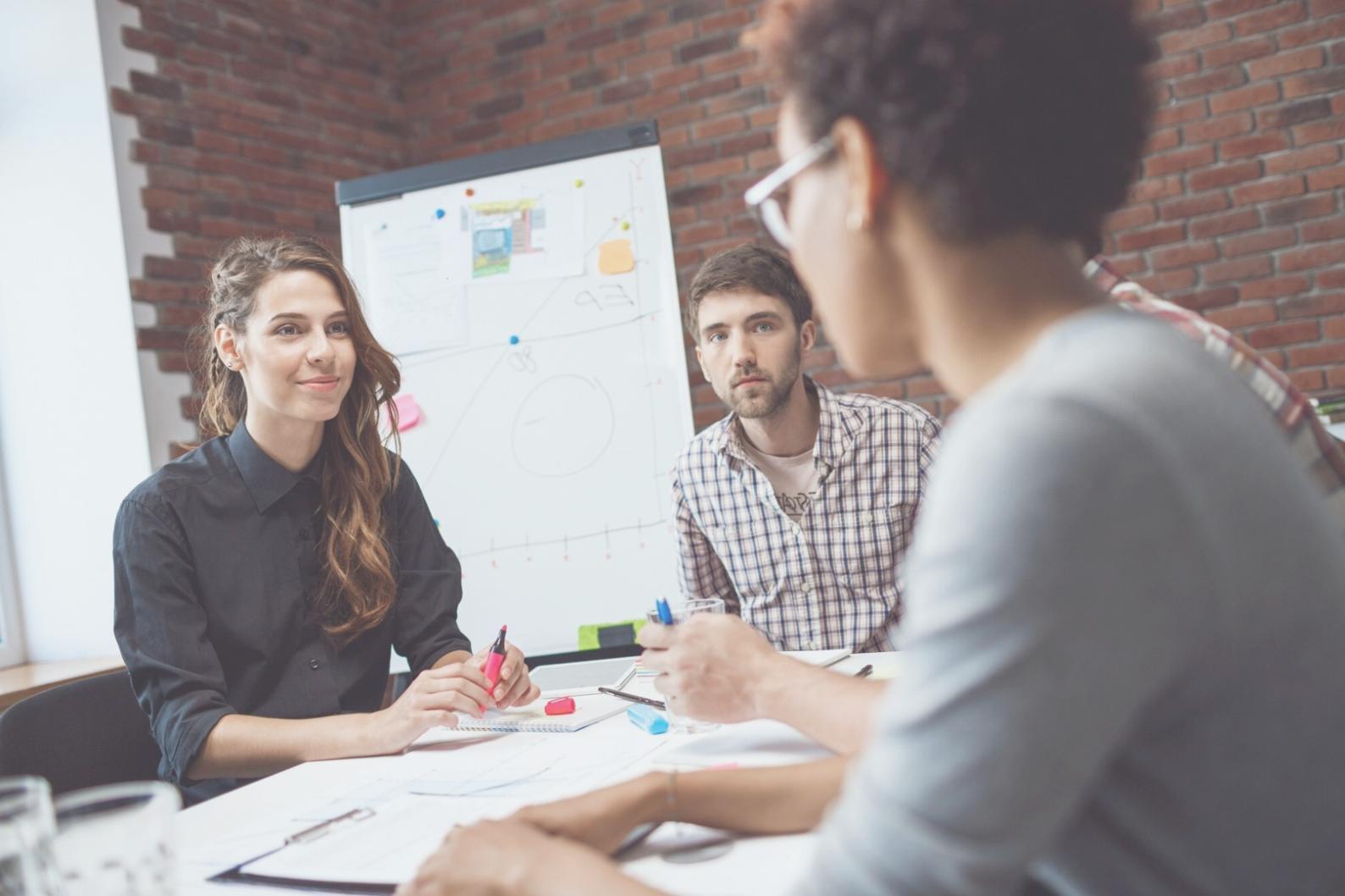 Sesión de trabajo colaborativo con equipo analizando documentos financieros y compartiendo estrategias